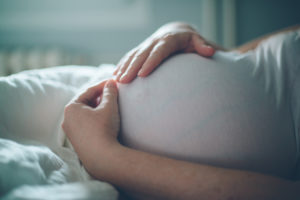 Woman holding pregnant belly thinking about hiring a doula  | CU Medicine OB-GYN East Denver  (Rocky Mountain)