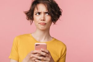 Woman with a smartphone in her hands and a confused look about birth control myths | CU Medicine OB-GYN East Denver (Rocky Mountain) | Denver